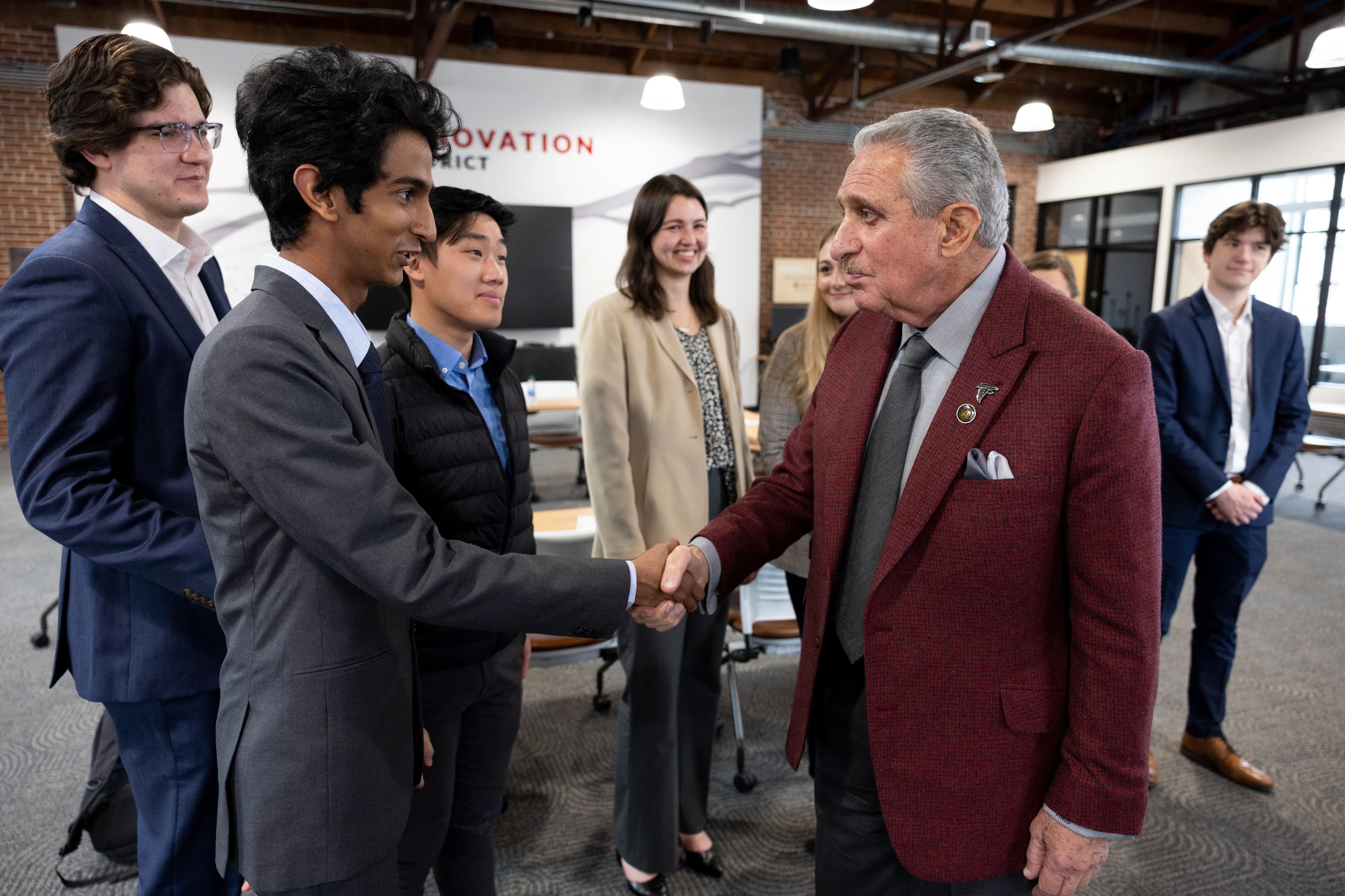 Business students shake hands